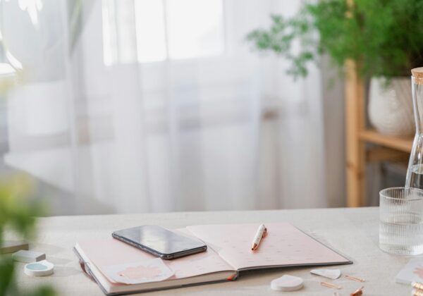 a table with a cell phone and a glass of water